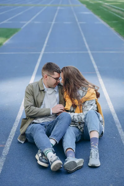 Foto Eines Paares Das Auf Einem Leeren Fußballfeld Sitzt Und — Stockfoto
