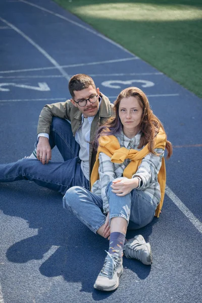 Foto Eines Paares Das Auf Einem Leeren Fußballfeld Sitzt — Stockfoto