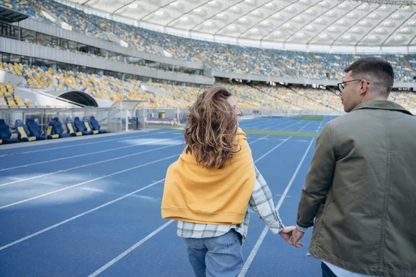 경기장에서 장난치고 커플의 소녀와 남자가 경기장 주변을 — 스톡 사진