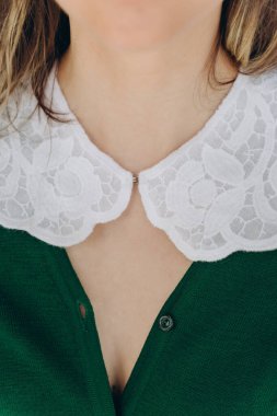 Yakından bakınca, mavi odada beyaz dantelli yakalı yeşil bir elbise giymiş güzel bir kadın görünüyor.