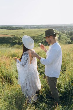 Young man helping his wife with strings on her beautiful guipure dress