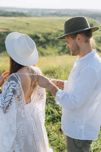 Young man helping his wife with strings on her beautiful guipure dress