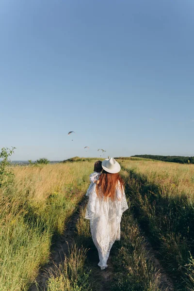 Beautiful Woman White Guipure Dress Holding Her Daughter Walking Field — Stok fotoğraf