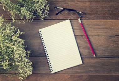 Boş küçük not defteri ve kalem ahşap masa üzerinde. Üzerinden görüntülemek 