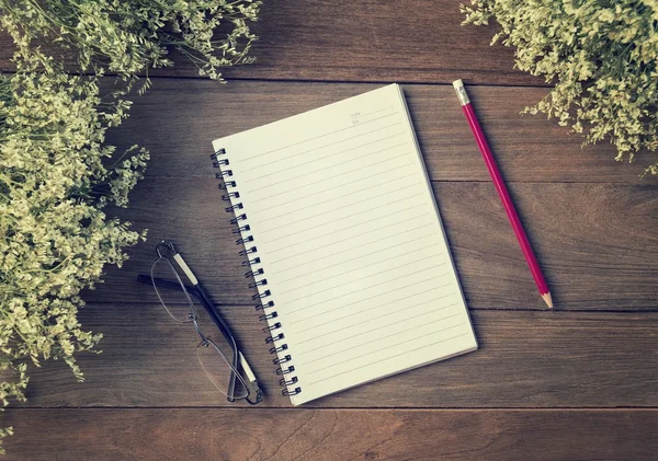 Boş küçük not defteri ve kalem ahşap masa üzerinde. Üzerinden görüntülemek 