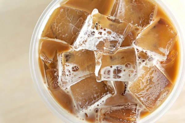 Close up top view cold coffee drink with ice on old wood table — Stock Photo, Image