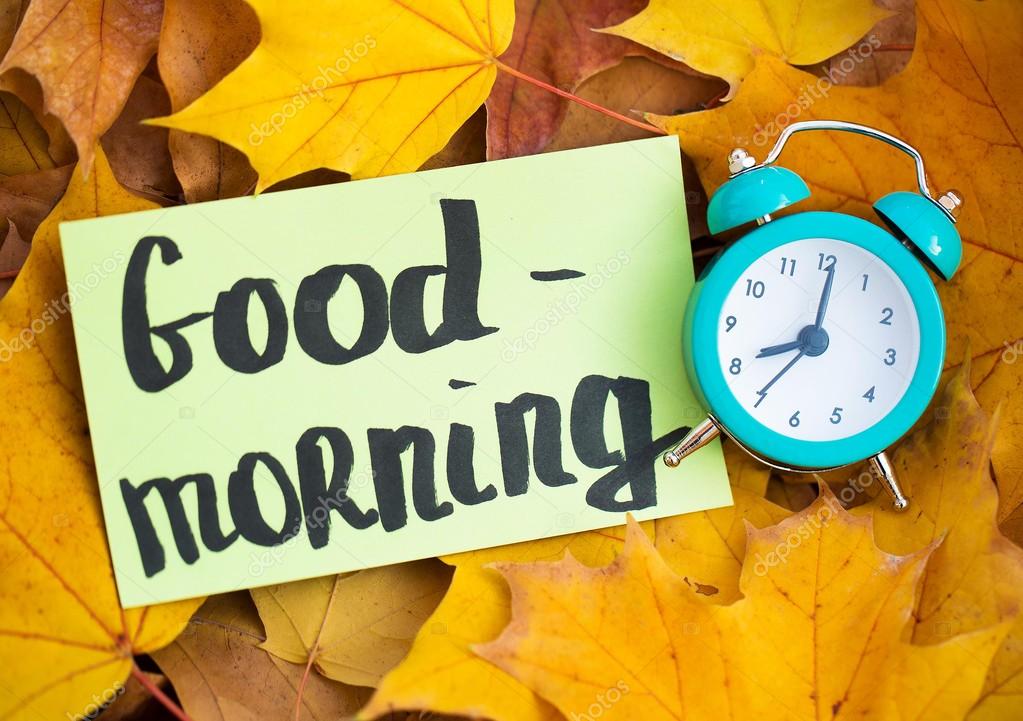 Alarm clock and note Good morning on the yellow autumn leaves — Stock