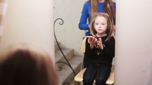 Peluquero peinando su cabello de linda niña — Vídeo de stock