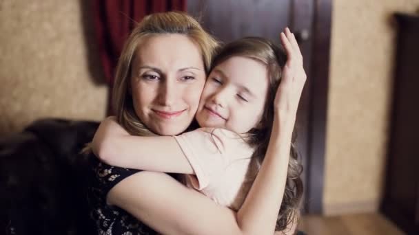 Kleines Mädchen umarmt seine Mutter auf dem Bett — Stockvideo