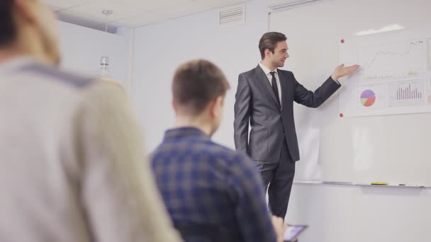 Zakenman presenteren aan het team voor het maken van notities in de bestuurskamer. Statische opname — Stockvideo