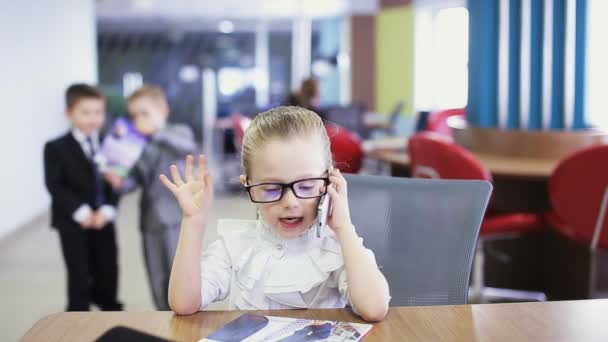 Офісна дитина розмовляє по телефону і висловлює емоції — стокове відео