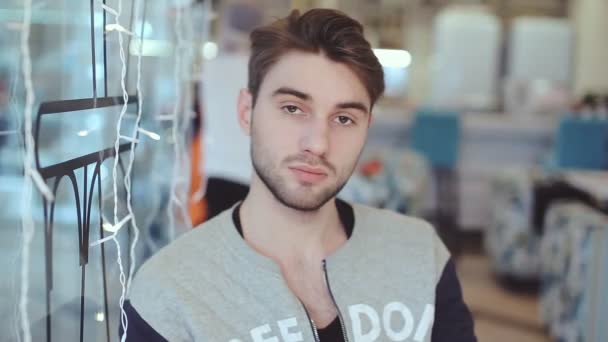 Mladý muž při pohledu na fotoaparát v kavárně — Stock video