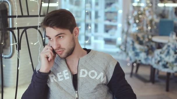 Joven hablando por celular en la cafetería — Vídeo de stock