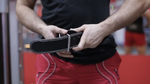 L'atleta stringe la cintura di sollevamento. rallentatore — Video Stock