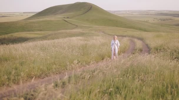 Woman in white dress walking in the field — Stock Video