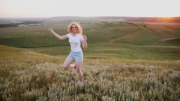 Cheerful girl dances and shake on sunset background — Stock Video