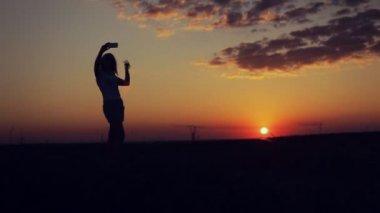 kız üstünde tepe dağ günbatımı arka plan üzerinde selfie al