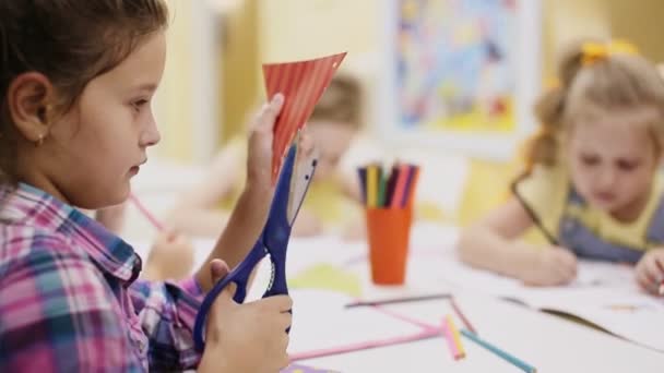 Niña con tijeras corta papel — Vídeos de Stock