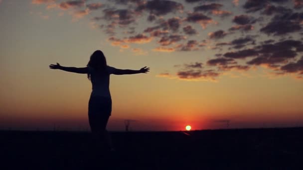 Sylwetka kobiety przędzenia na tle zachodu słońca — Wideo stockowe