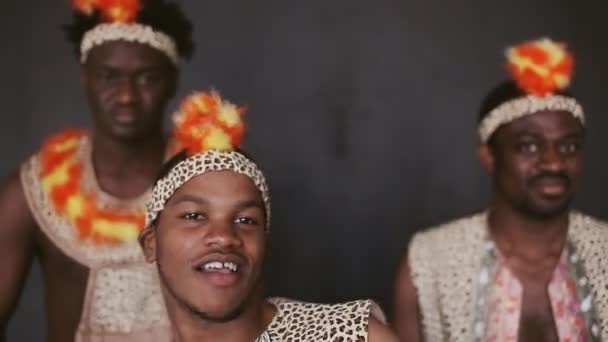 Три африканца танцуют и играют на барабанах — стоковое видео