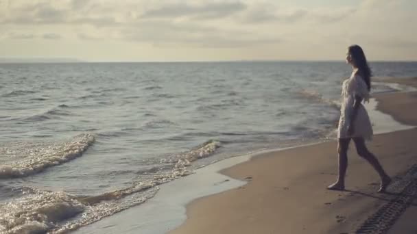 Joven chica de pie en la playa — Vídeo de stock