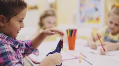 Yong kız makasla kağıdı keser