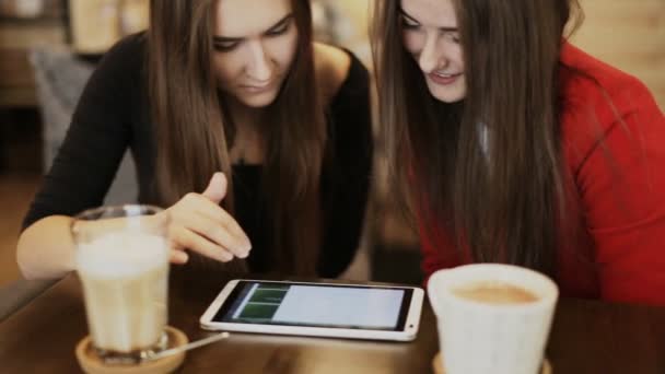 Dos amigas felices con sonrisa de tableta en la cafetería — Vídeo de stock