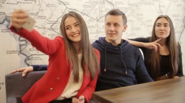 İki mutlu kız ve erkek selfie kafede alarak