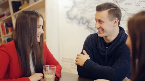 Ragazzo e due ragazze ridendo e parlare in caffè — Video Stock