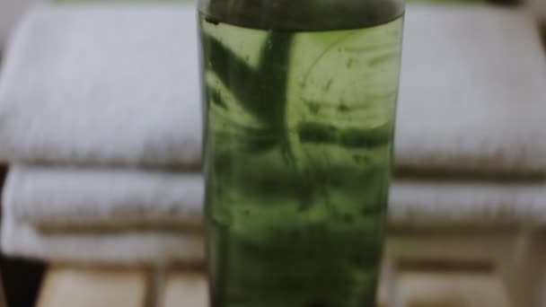 Botella verde de aceite de masaje y toweks — Vídeos de Stock