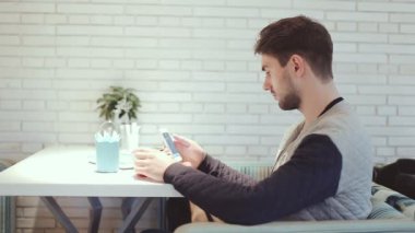 Kafede oturan smartphone ile genç adam