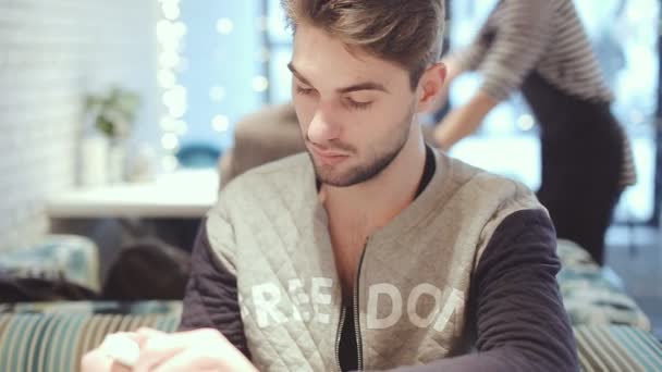 Jonge man met smartphone zitten in Cafe, close-up — Stockvideo