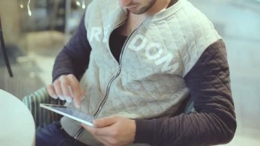 Tablet bilgisayar kafede oturan genç adam