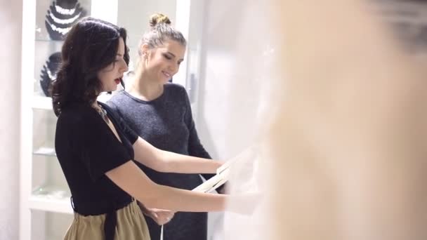 Namoradas escolhe vestido de casamento na boutique — Vídeo de Stock