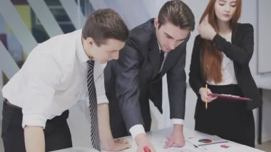 Ofis çalışanları çizim görüntülemek ve projeyi tartışmak