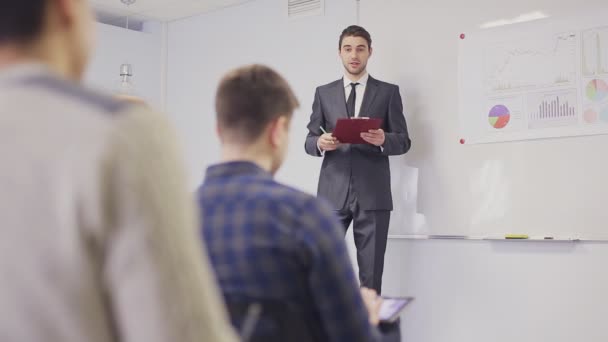 Homme d'affaires présentant à l'équipe prenant des notes dans la salle de réunion. Plan statique 
