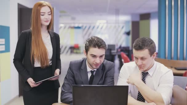 Büroangestellte schauen auf Laptop und diskutieren. — Stockvideo