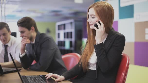 Kızıl saçlı kız ofiste telefonda konuşuyor — Stok video