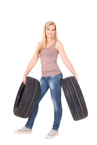 Beautiful woman holding tyres. — Stock Photo, Image