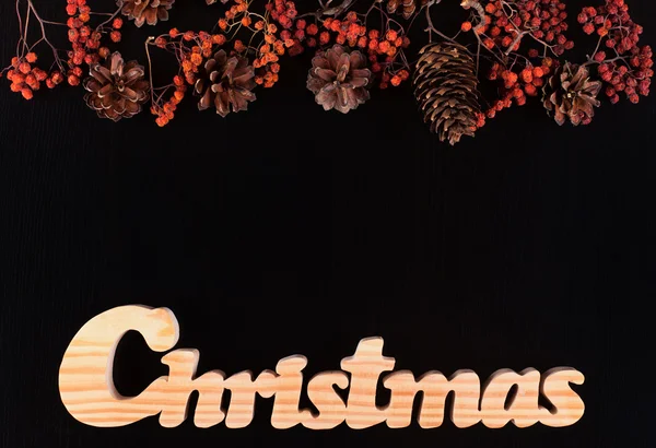 Baies séchées, cônes et écriture de Noël sur un fond de pin noir — Photo