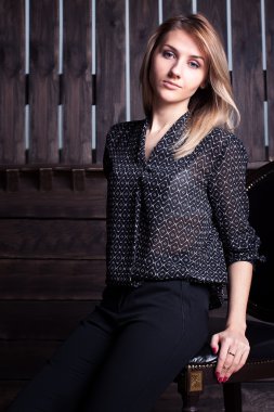 Muhteşem bir kadın bir tahta sandalyede eğildi