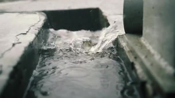 Strömendes Wasser strömt aus dem Abflussrohr an einem Regentag. — Stockvideo