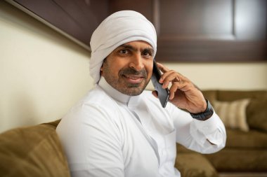 Arap işadamı evde akıllı telefon kullanıyor 