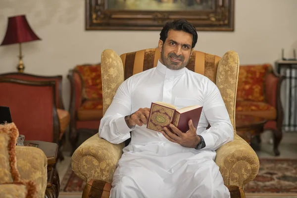 Arab Muslim man reading the holy book the Quran Karee