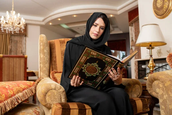 Arabian woman wearing Hijab reading islamic Holly book Quran Kareem