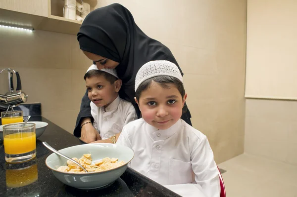 母と朝の朝食を持っている 2 人の子供のアラビア家族 — ストック写真