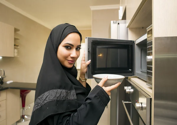 Wanita muda cantik di dapur menggunakan oven microwave — Stok Foto