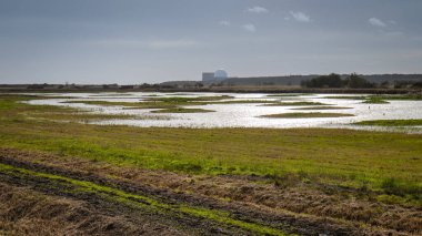 Soğuk bir sonbahar akşamı gün batımında Sizewell B Nükleer Santrali Nükleer Santrali 'ne bakan bir manzara.