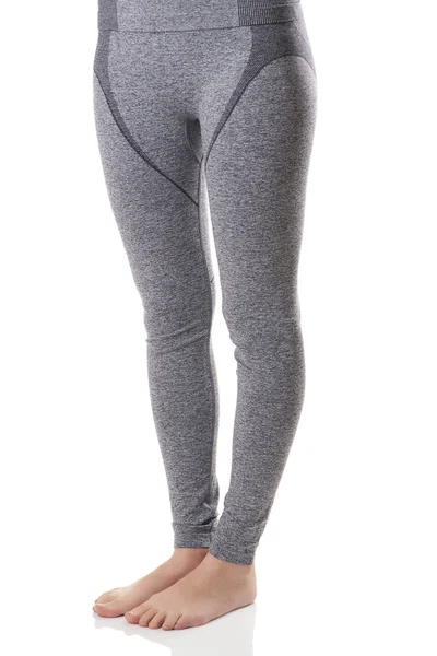 Vista de pernas de mulher apto do lado da frente em esportes cinza roupa interior térmica com padrão . — Fotografia de Stock
