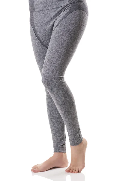 Vista de cerca de las piernas de la mujer desde el lado frontal en ropa interior térmica deportiva gris con patrón . —  Fotos de Stock